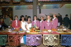 Group with platters of food on serving table in Mexico Pavilion
